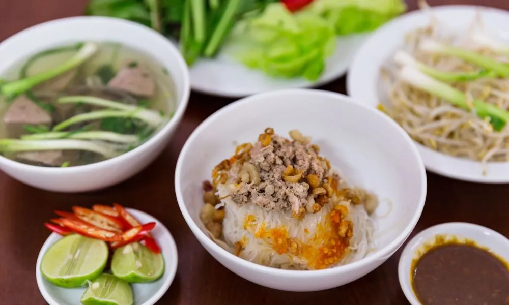 Một suất phở khô Gia Lai đầy đủ gồm tô phở trộn, tô nước lèo và giá trụng